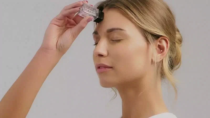 Gently pressing the HoMEso applicator onto the forehead